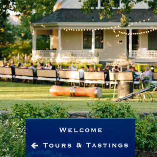 Blue welcome sign at St. Supéry estate with the Atkinson house in the background